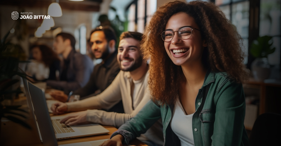 várias pessoas sorriem sentadas a mesa enquanto estudam